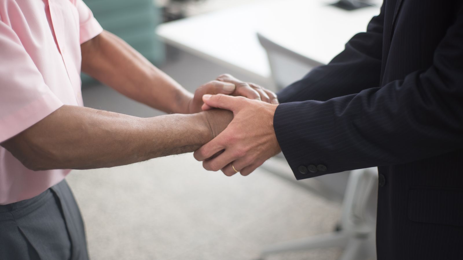 Poignée de mains formelle entre deux dirigeants lors d'une opération de fusion-acquisition en Belgique