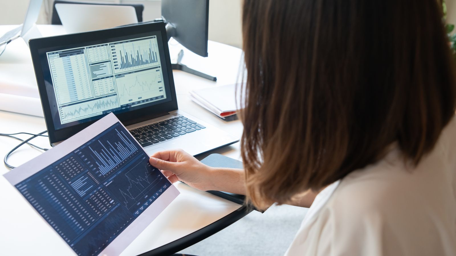 Compliance officer die AML-screeningmeldingen analyseert op een computerscherm op het kantoor