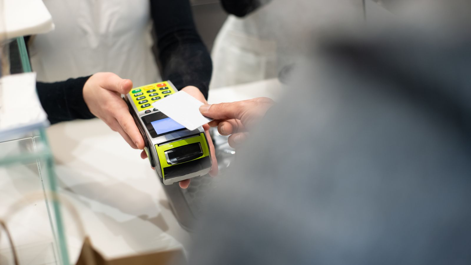 Klant die met een kaart betaalt aan een betaalterminal bij een agent, ter illustratie van de AML-verplichtingen van distributienetwerken in België