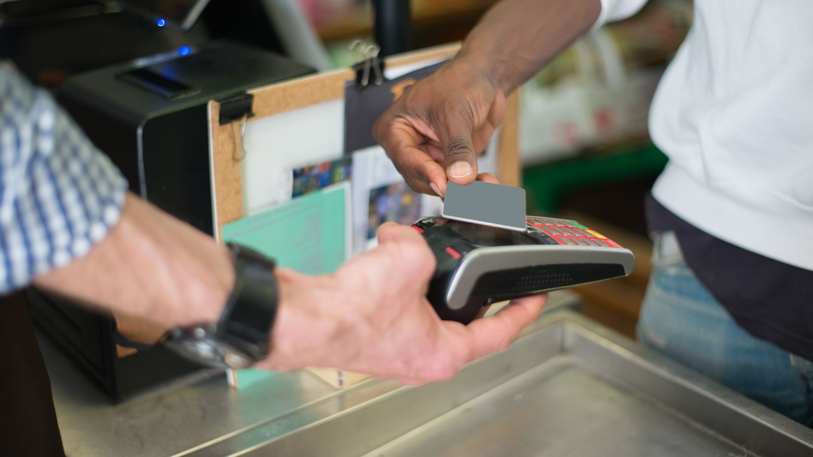 Paiement sans contact par carte sur un terminal, illustrant les obligations AML des établissements de monnaie électronique en Belgique