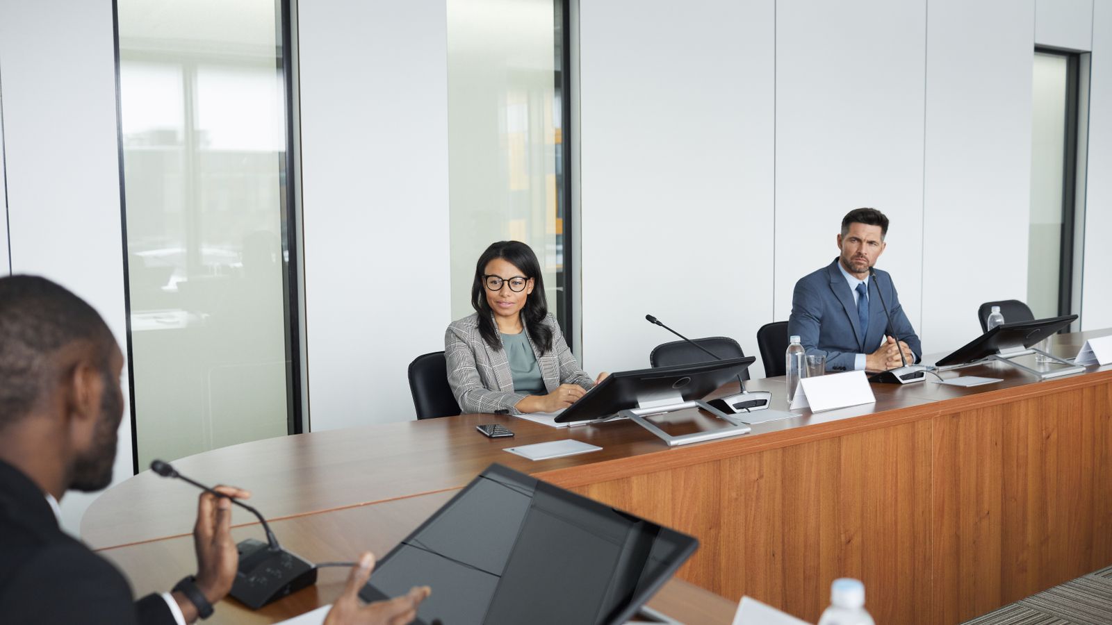Professionnels dans une salle de réunion moderne discutant de la politique groupe AML et des obligations AMLR